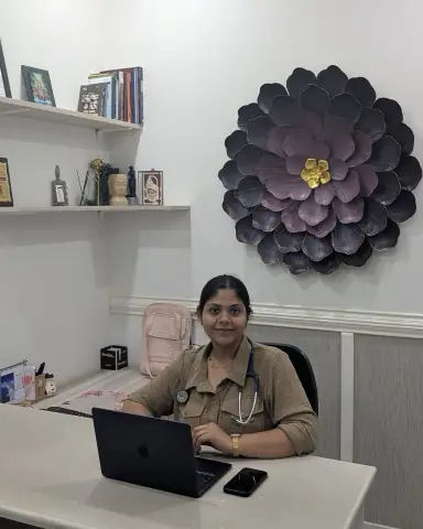 Dr. Richa Chandra at her desk at Ekam, a crafted dahlia on the wall behind her and a stethoscope in front of her.