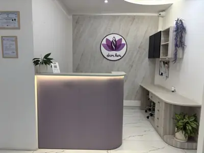 The reception desk at Ekam, empty, with the clinic mark on the wall behind it.
